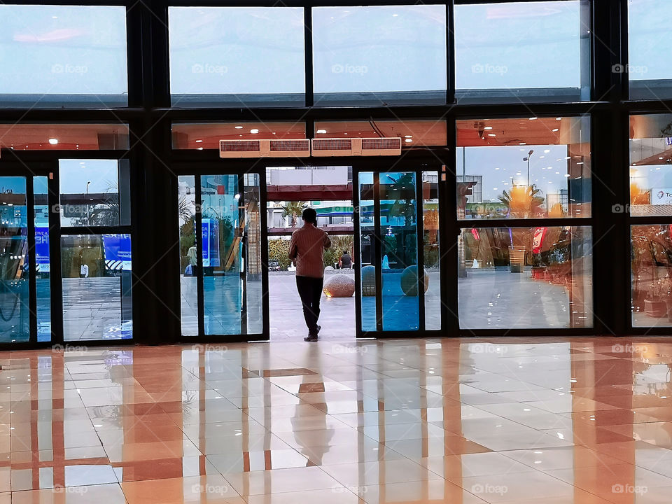 A man walking out of the mall.