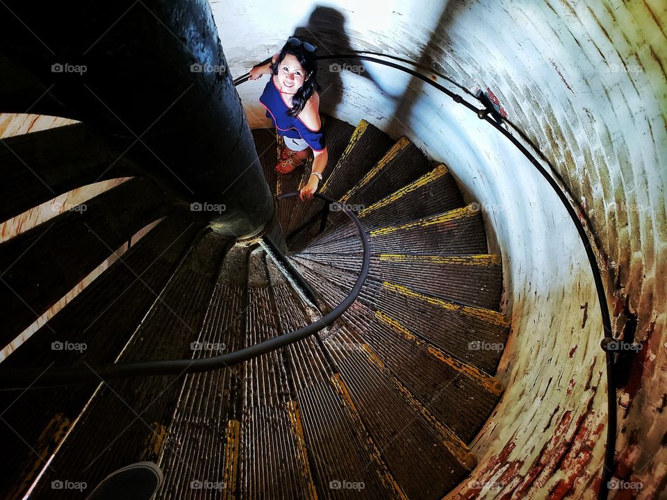 Beautiful woman in spiral staircase of lighthouse