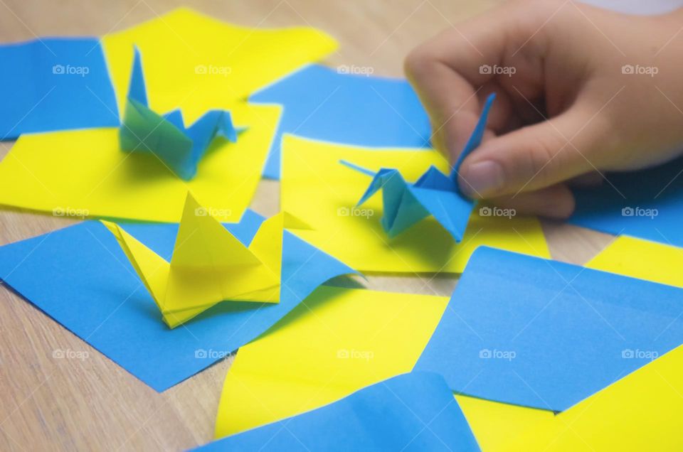 a child makes a crane out of paper