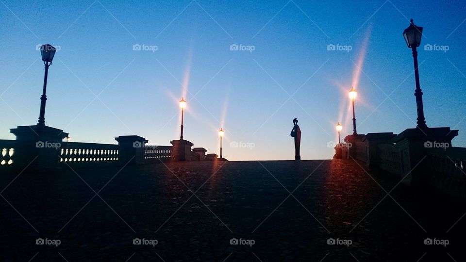 View up the ramp from Steenplein towards the Scheldt river bank, early evening, in Antwerp, Belgium. Godin Minerva statue visible as silhouette
