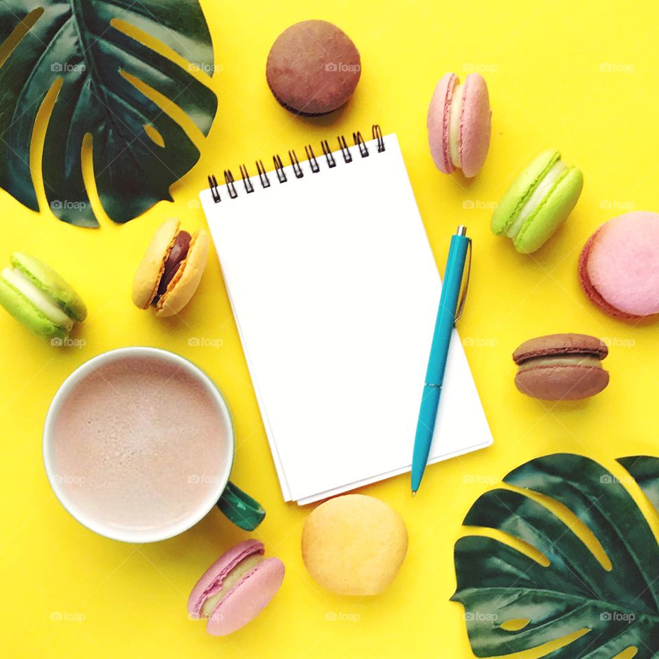 Yellow flat lay with coffee and macaroons