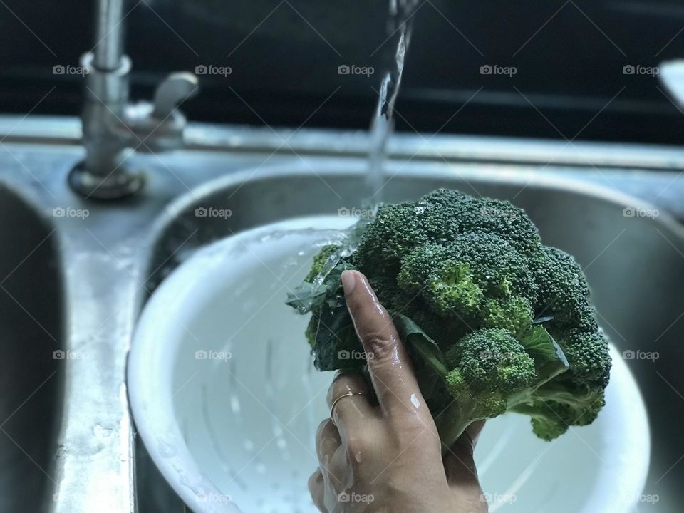 Cleaning broccoli under running water 💦