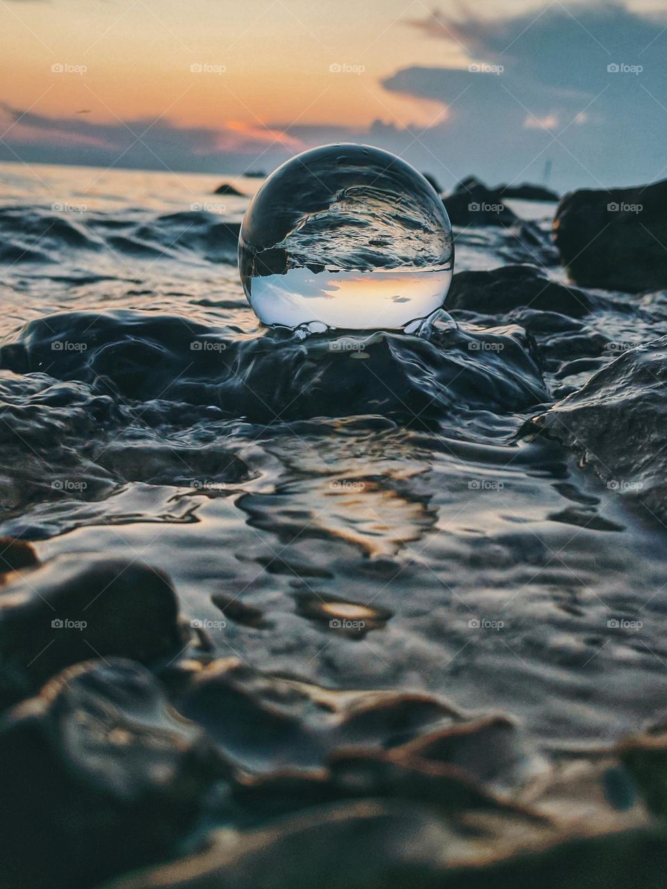 Top view of lensball,  crystal ball at the Adriatic seaside against sunset sky close up