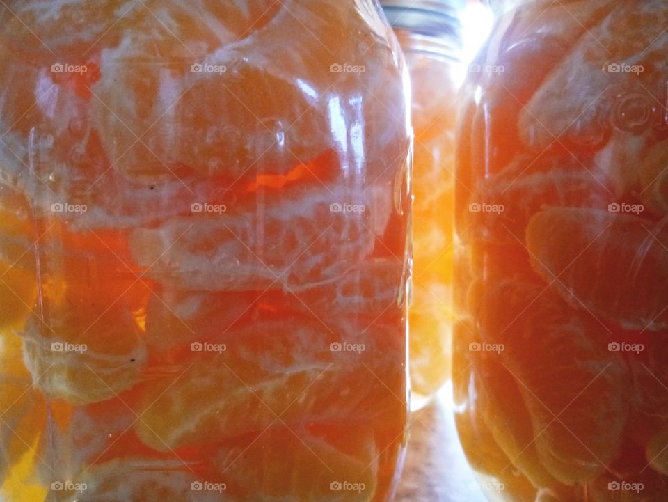 mandarin segments preserved in light syrup in glass mason jars closeup