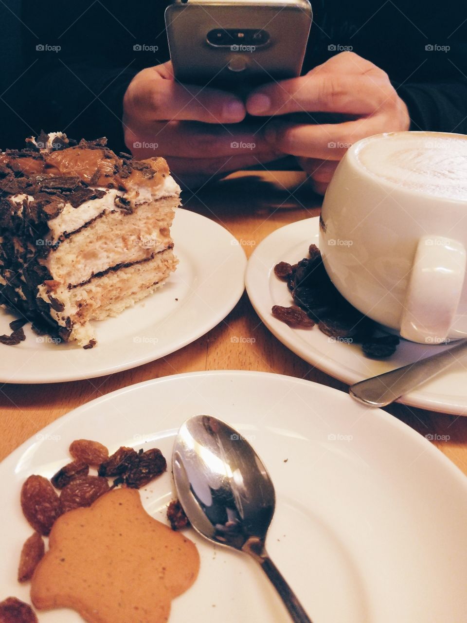 Man taking photos of cake and coffee