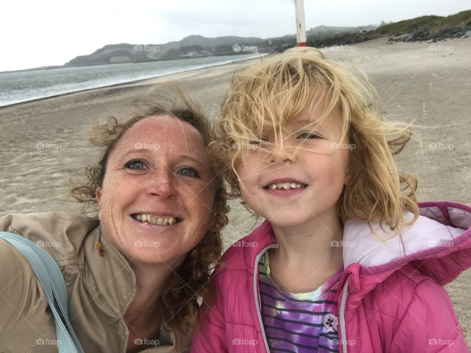 Mother and daughter on a windy beach in Ireland