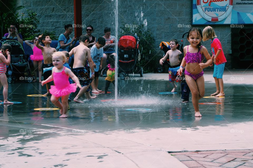 Children playing under the fountain
