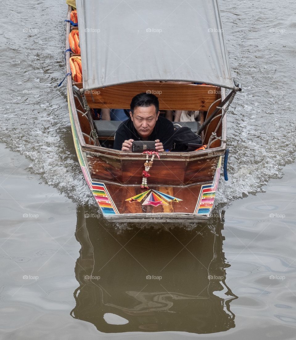 Tourist try to take photo in the boat