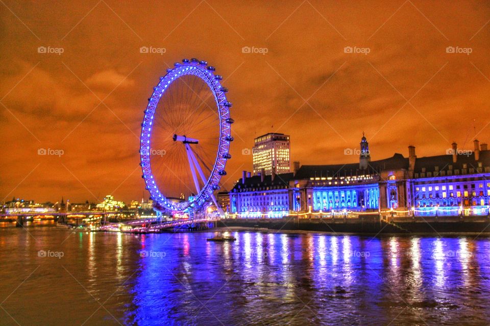 The London Eye by night. All light up reflecting on river Thames. Central London is always an amazing place to be. 