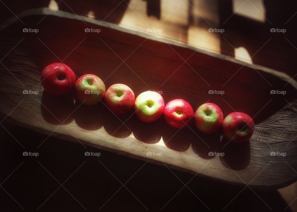 Organic apples in a wooden bowl on a table from above