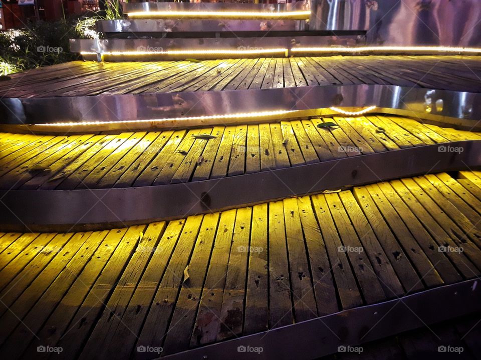 Colored lights along the steps and steps  Shine bright at night. Lights and shadows.