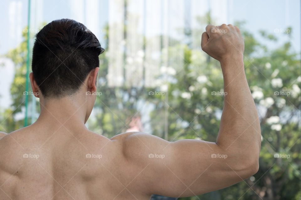 handsome man show muscle arm in the gym or fitness center, Health concept