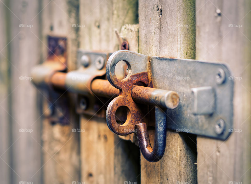 Old rusty metal lock on wooden doors