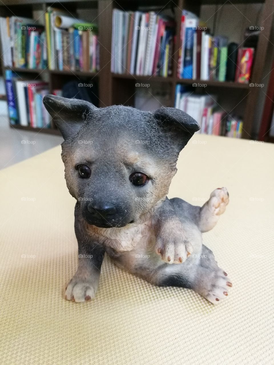 Ceramic dog with doubtfulface sitting on  sofa.