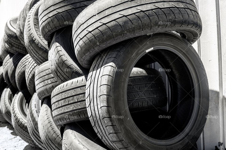 Background photo of used tires stacked on top of one another in closeup