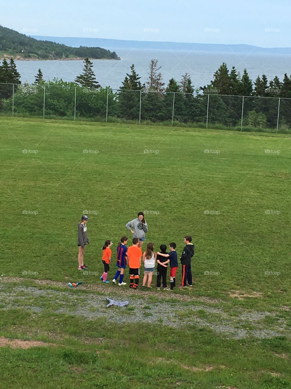 Kids at soccer practice learning from their coach. Team spirit. 
