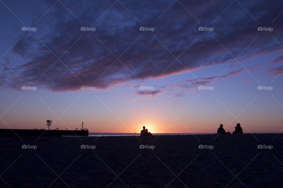 Couple looking sunset at the beach