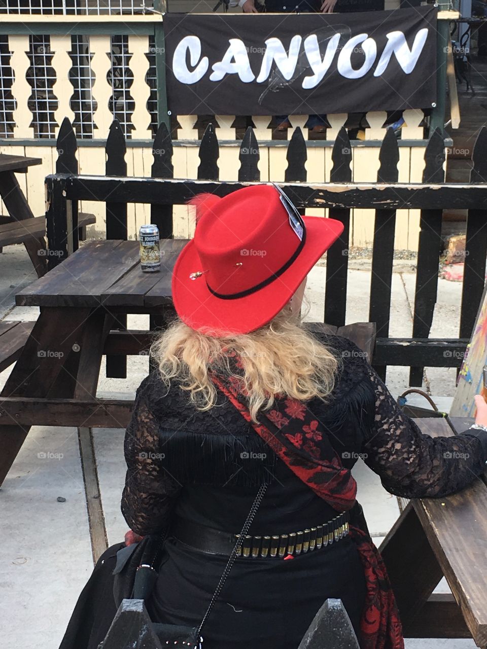 Blonde-haired Cowgirl wearing red felt cowboy hat 