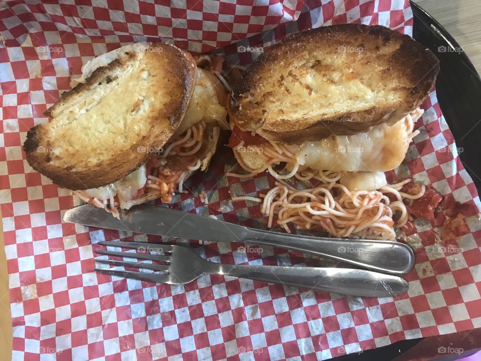 Spaghetti and cheese sandwiches with utensils on a checkered background 