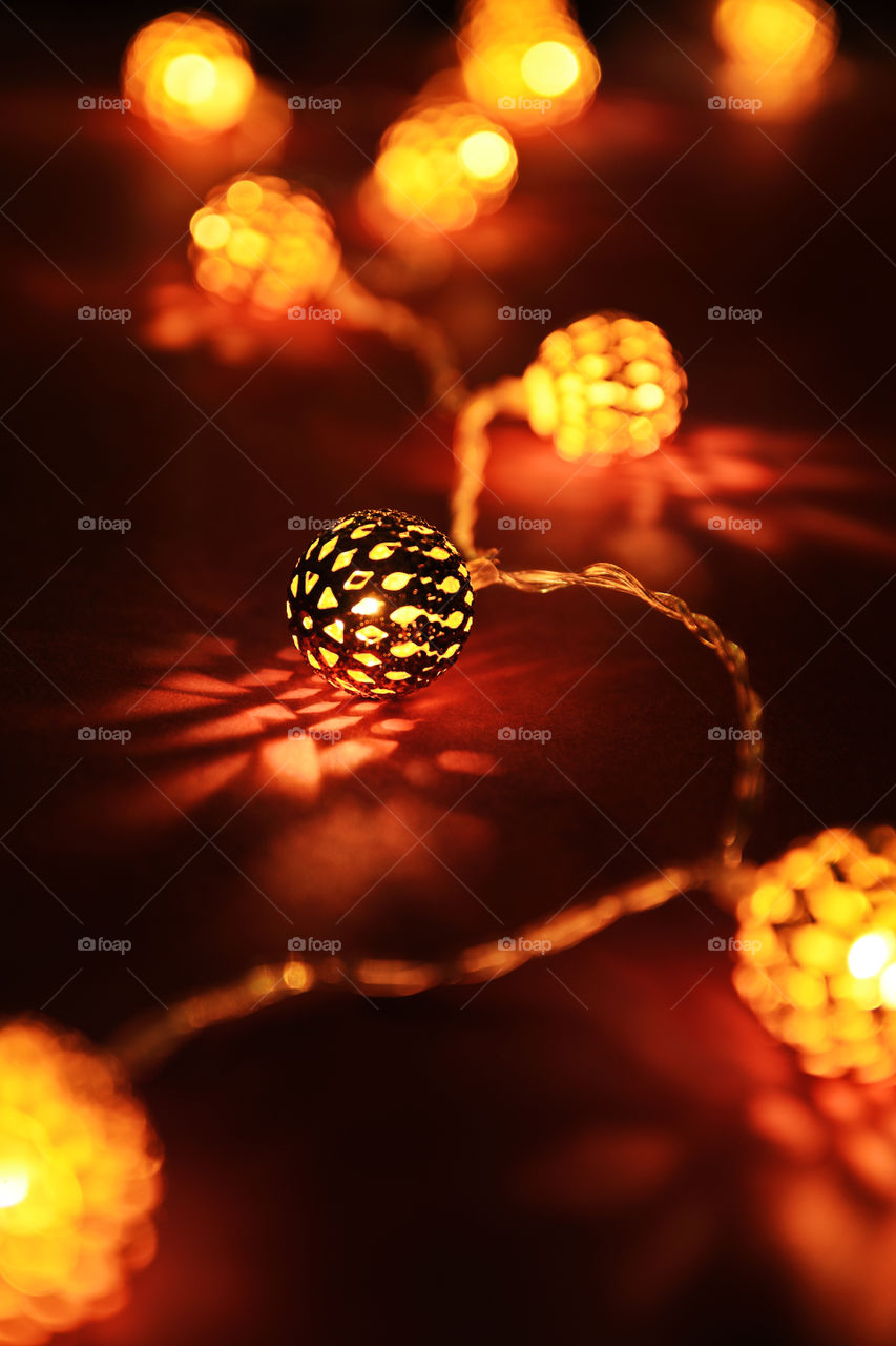 Close up shot of golden blurred Christmas lights making cozy and romantic atmosphere. Festive background with blurry lights.
