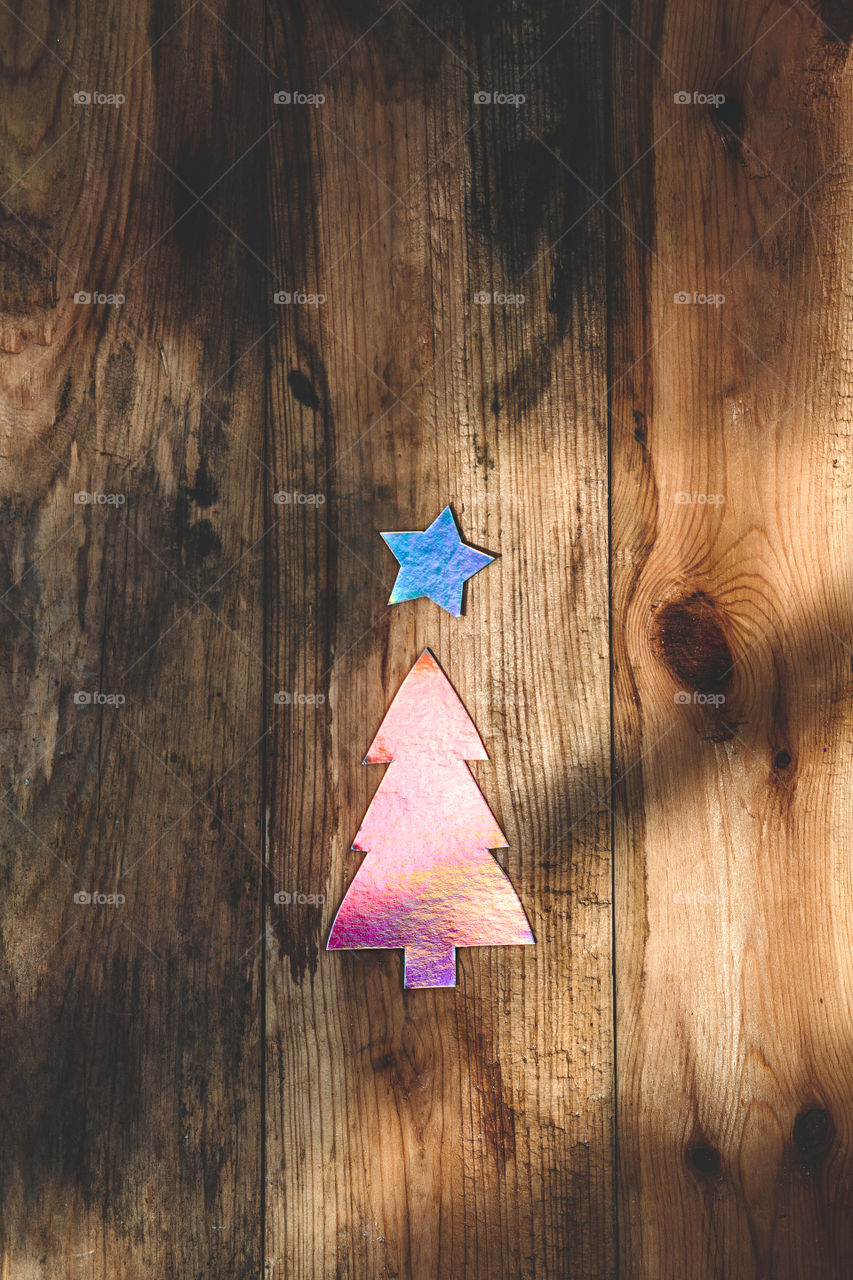 Paper cut out of christmas tree and star shape on wooden table