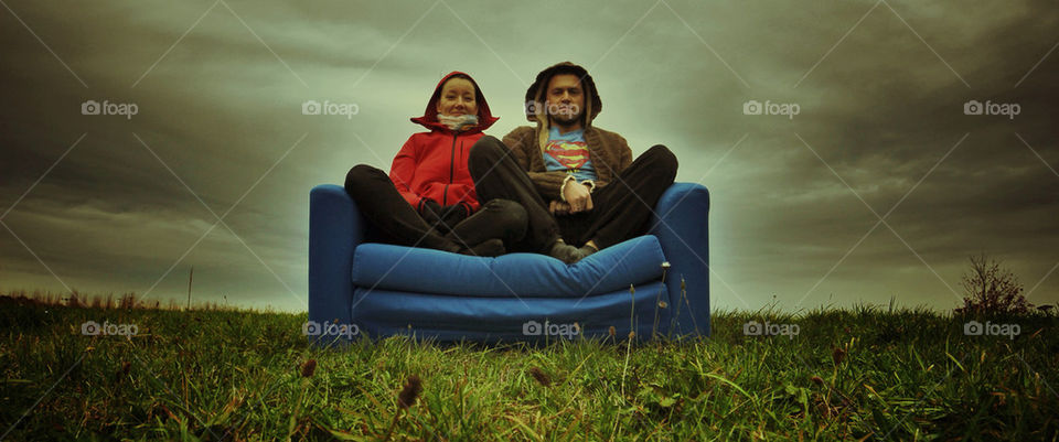 Couple on a sofa outside.
