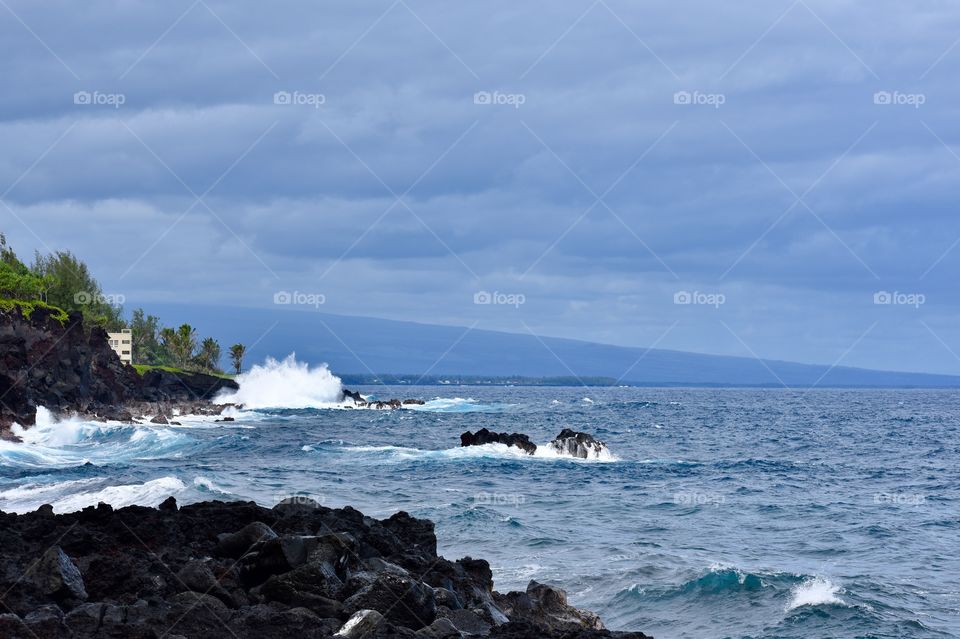 Seascape with the Mauna Loa volcano rising out of the ocean in the distance