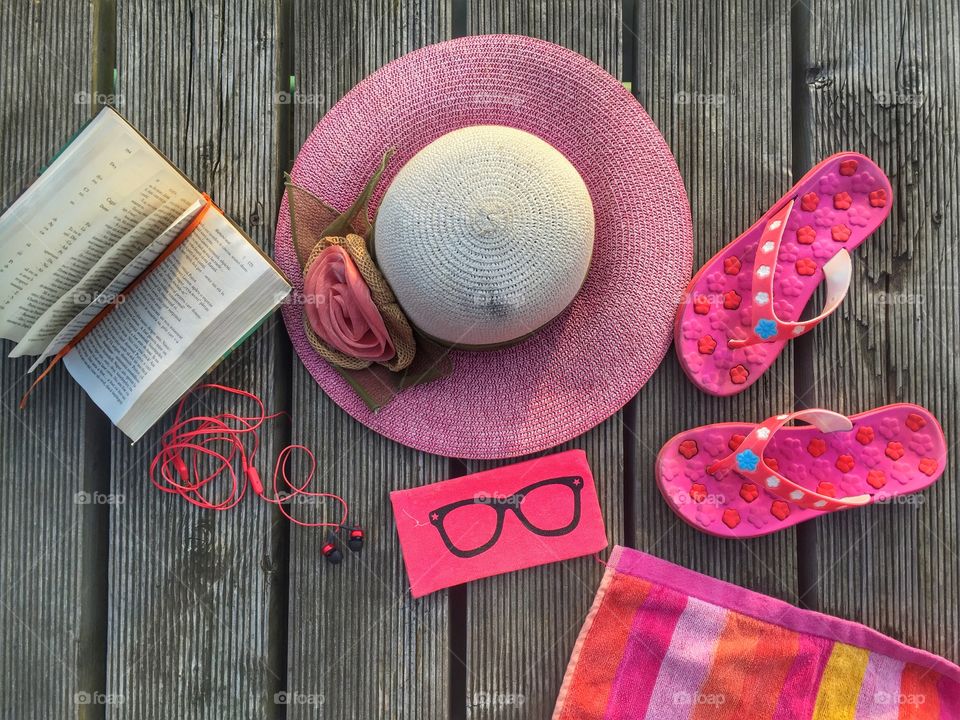 Pink flat lay summer items on wooden deck
