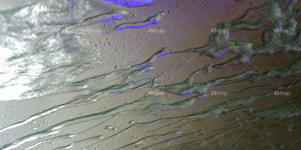 Water forced over glass with purple lighting.