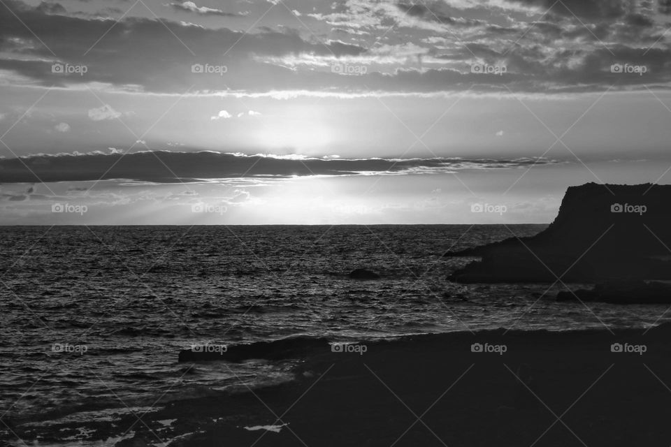 Sunset over the atlantic ocean with cloud sky in black and white 