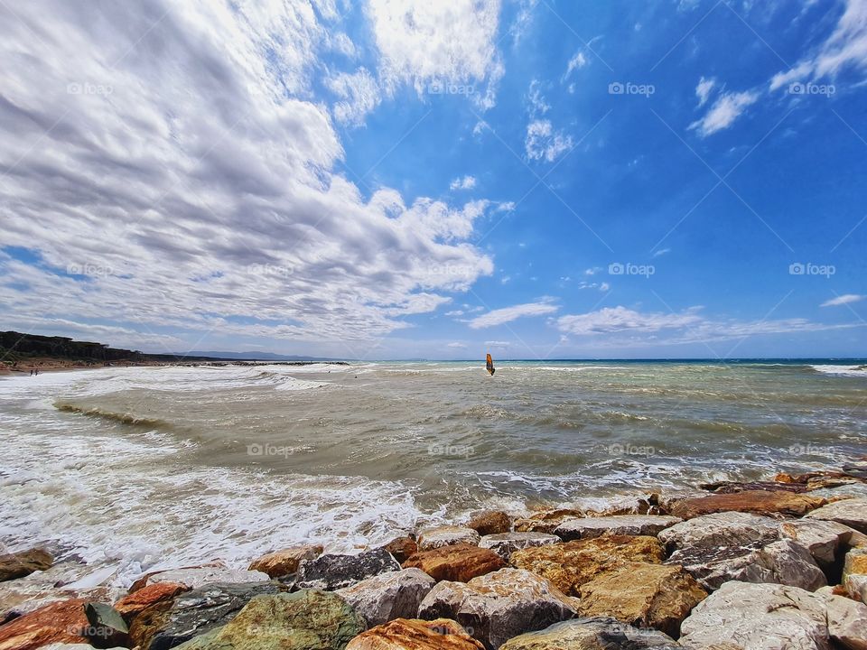 windsurf suspended between sea and sky