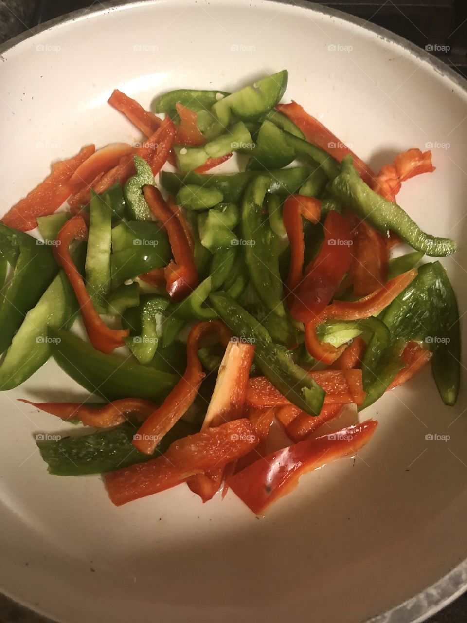 Colorful healthy green and red peppers cut lengthwise on a plate. 