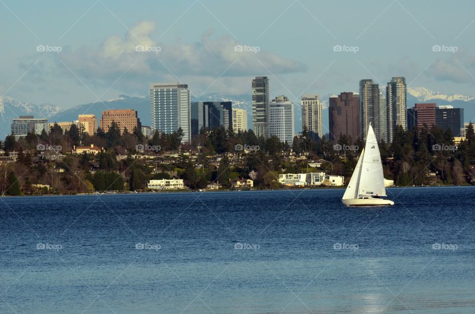 A Sailboat passing by the city