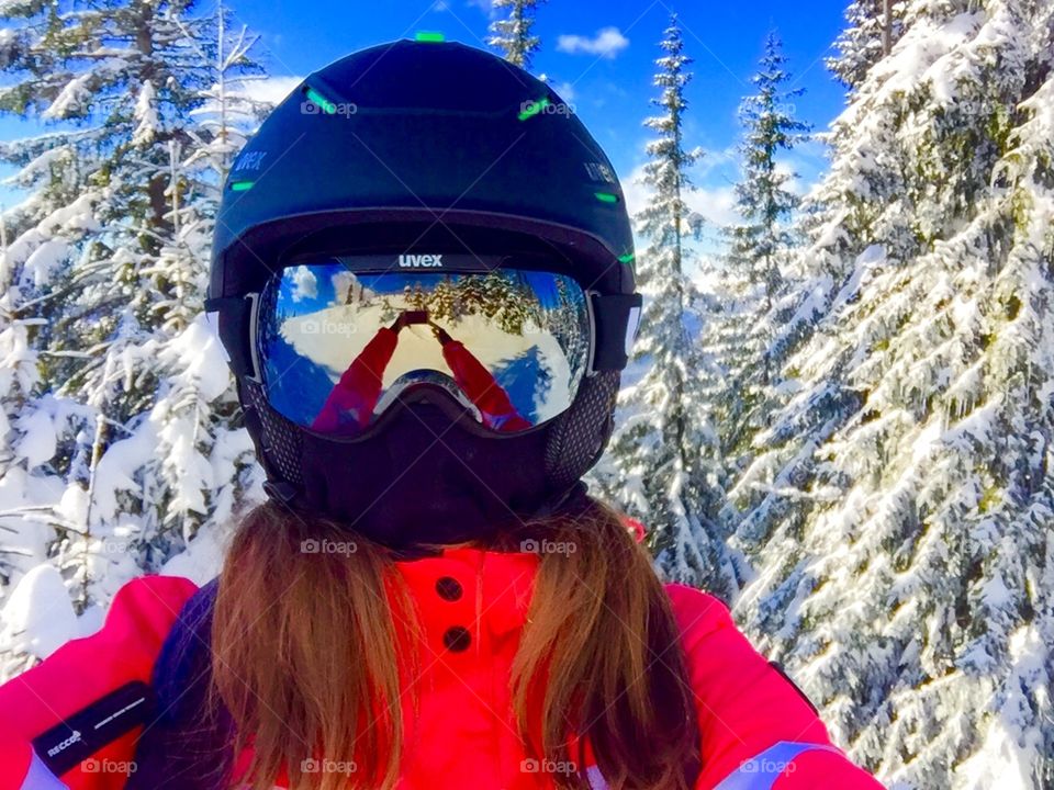 Selfie of woman with ski helmet,ski glasses and snow in the background