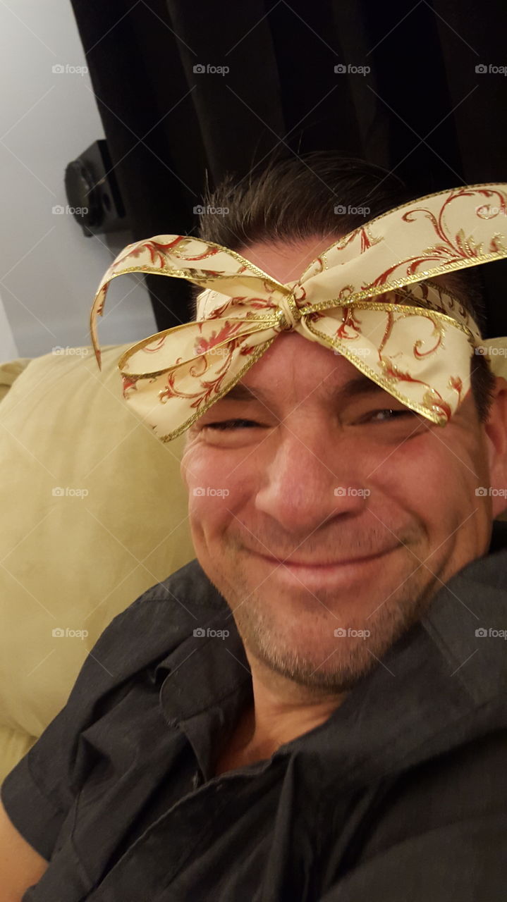 drunk man with Christmas bow in head