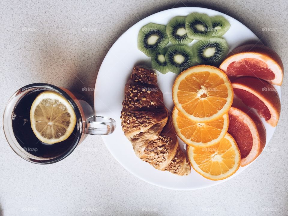 Close up of sliced fruits on plate and drink