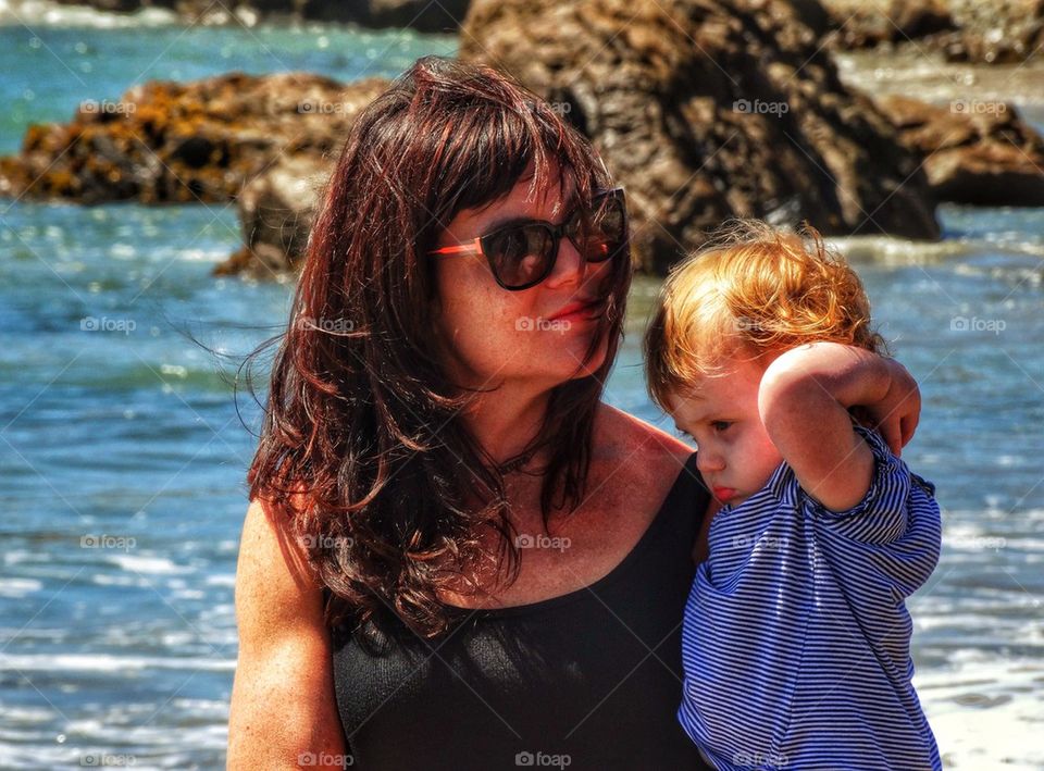 Sexy Muscular Mom With Daughter. California Mom Holding Her Toddler Daughter On The Rocky California Coast