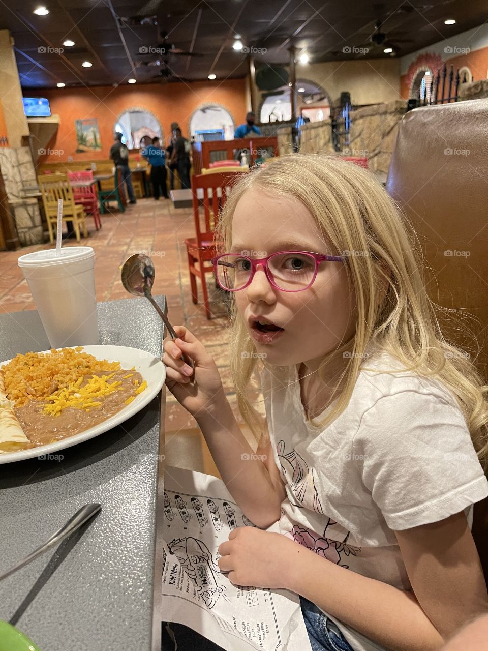 Little girl does not look happy about dinner