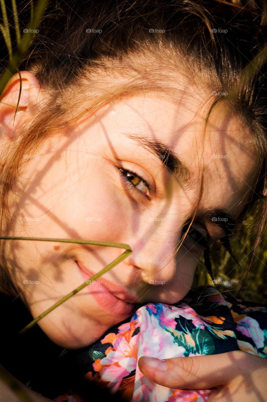 Close-up portrait of a girl. A girl with her hair tied up is caught in the light.