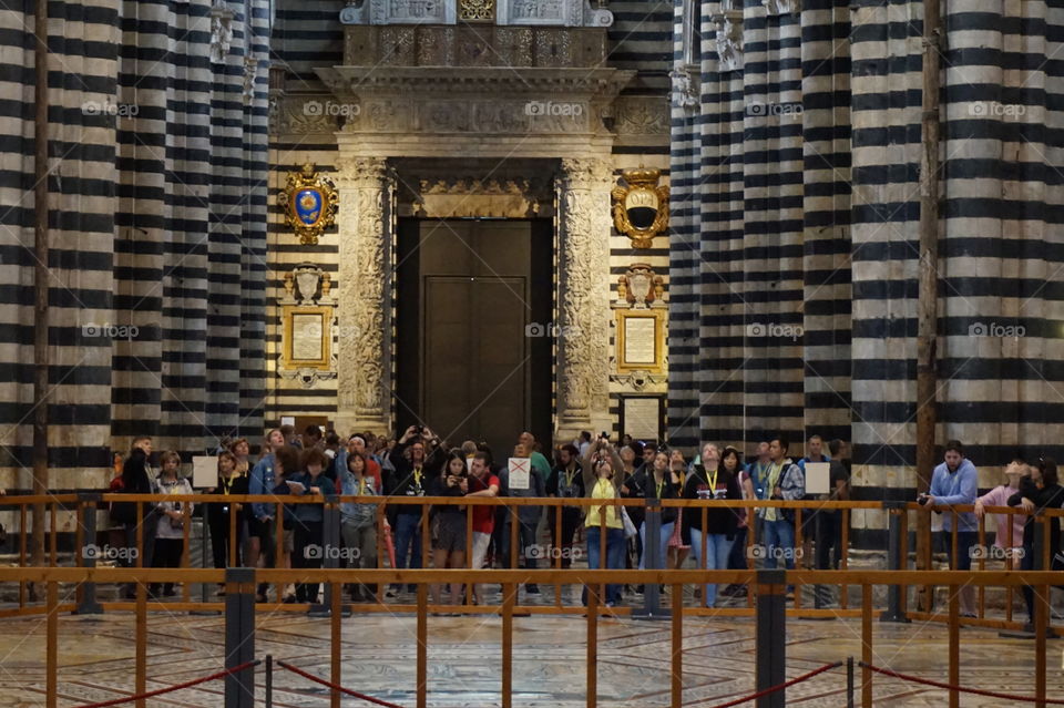 Crowd of tourists admiring an Italian cathedral.