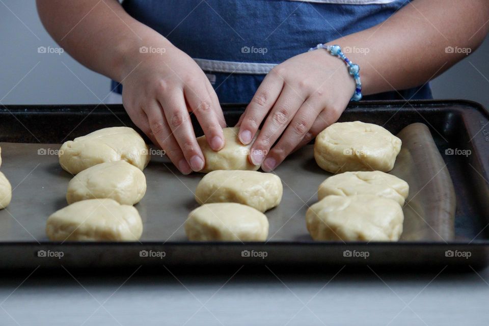 Child's hands are making buns