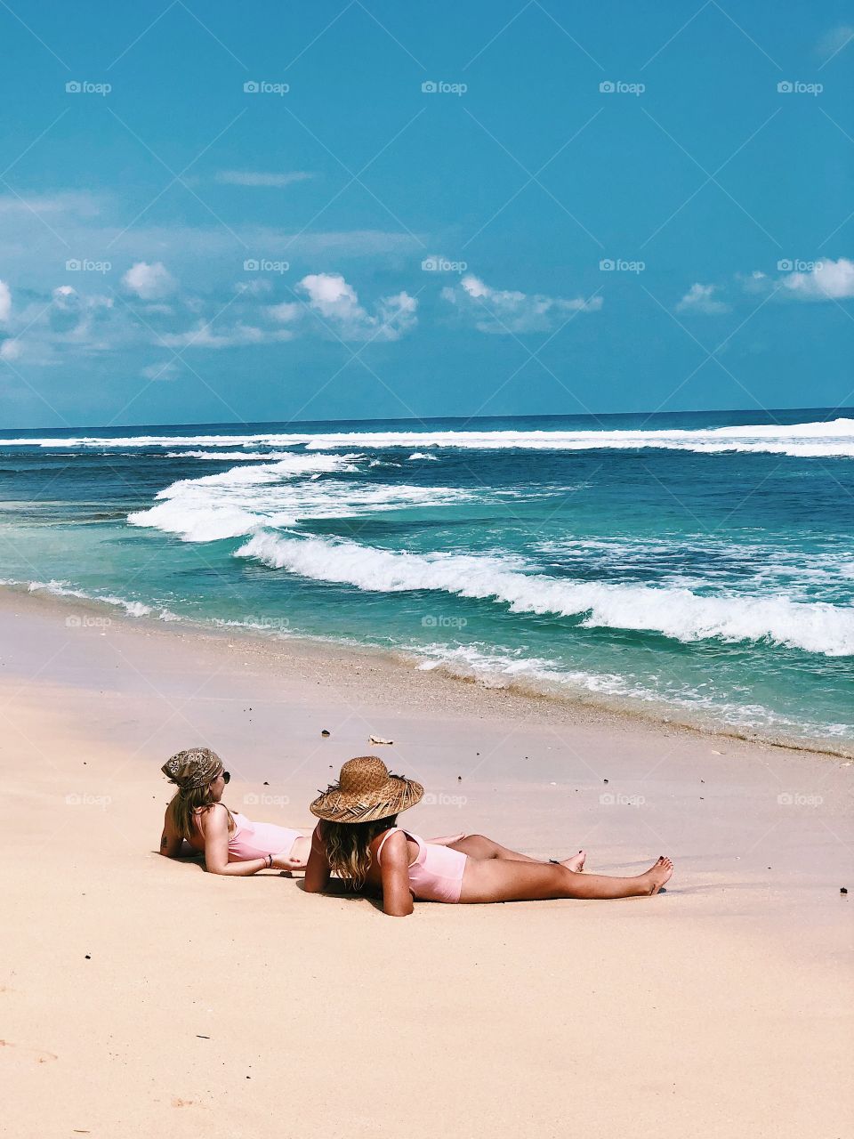 Photo taken at Nyang Nyang Beach, Uluwatu, Bali. These two eye catching girls just chillin by the beach with cute swimsuit and hats