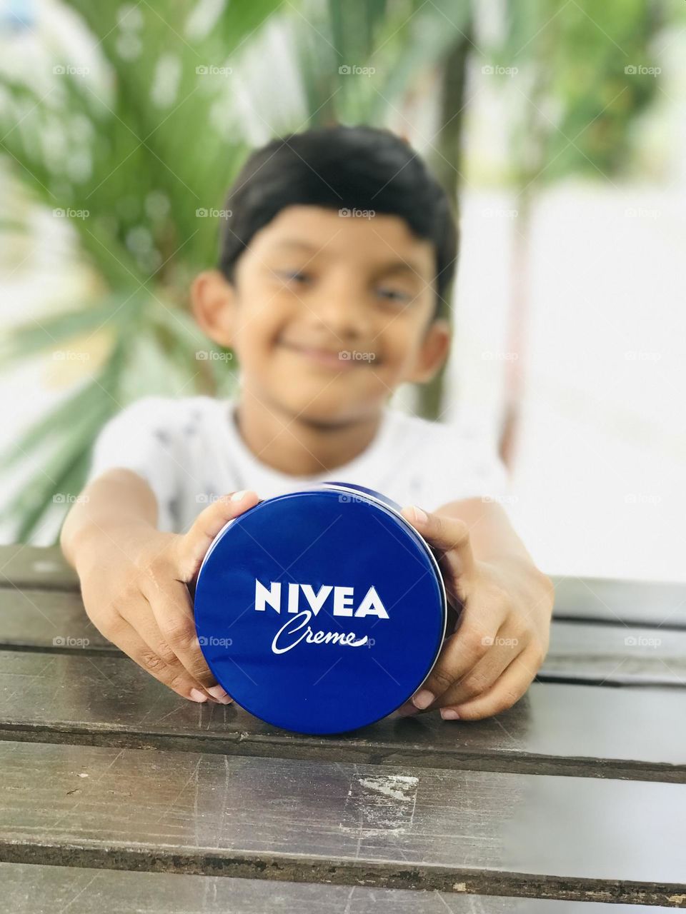 A boy with cute smile and Nivea cream.
