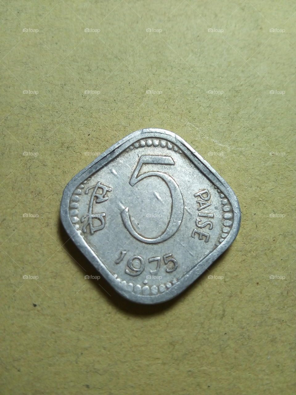 A coin of five paise- 1/20 share of Indian Rupee issued by Government of India in 1975.