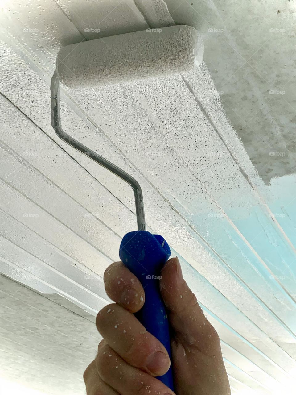 Painter At Work With White Paint On A Roller 