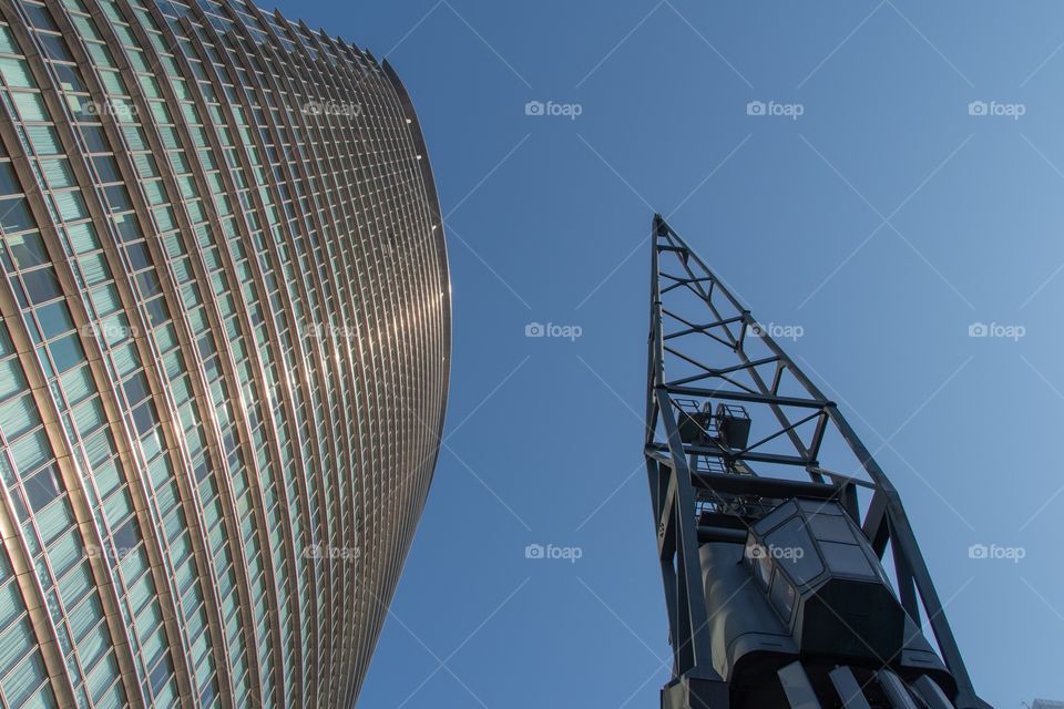 Dock crane landmark against a skyscraper at West India Quay in Canary Wharf