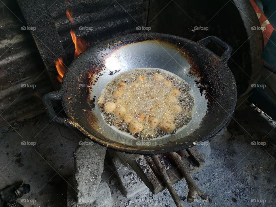 Fry something in the pan by using a charcoal stove.