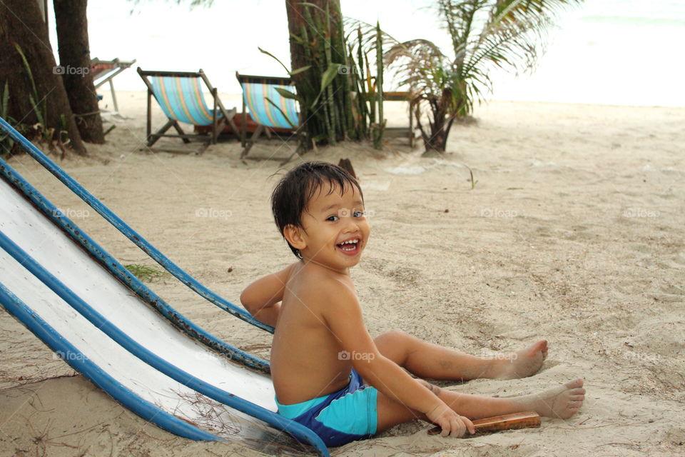 Kid having fun at the beach. Thithi play on the slide at the beach