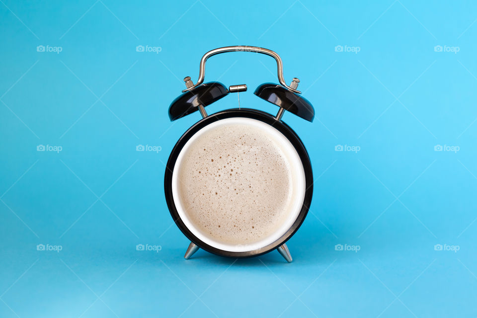 Wake up concept: alarm clock blended with cup of coffee