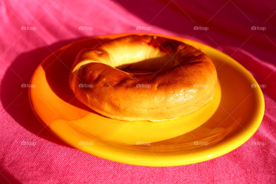 Miniature pie on a orange plate on pink background